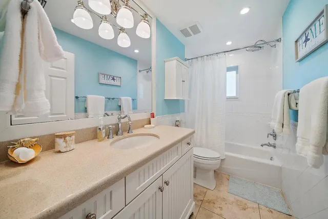 a bathroom with a granite countertop sink mirror vanity and toilet