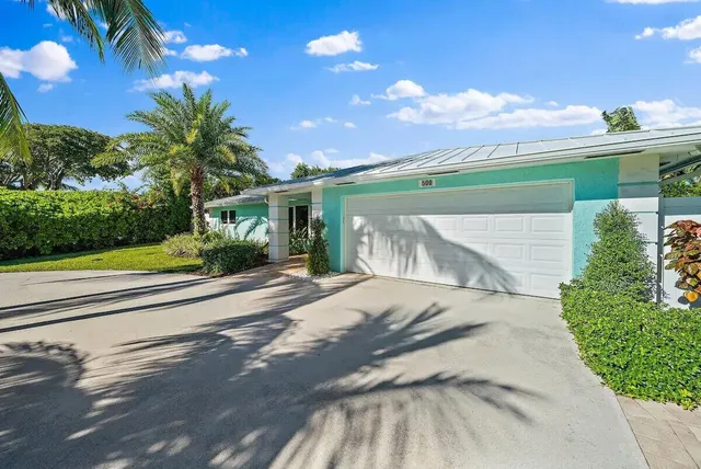 a view of a house with a yard and potted plants