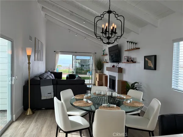 a view of a dining room with furniture a chandelier and wooden floor