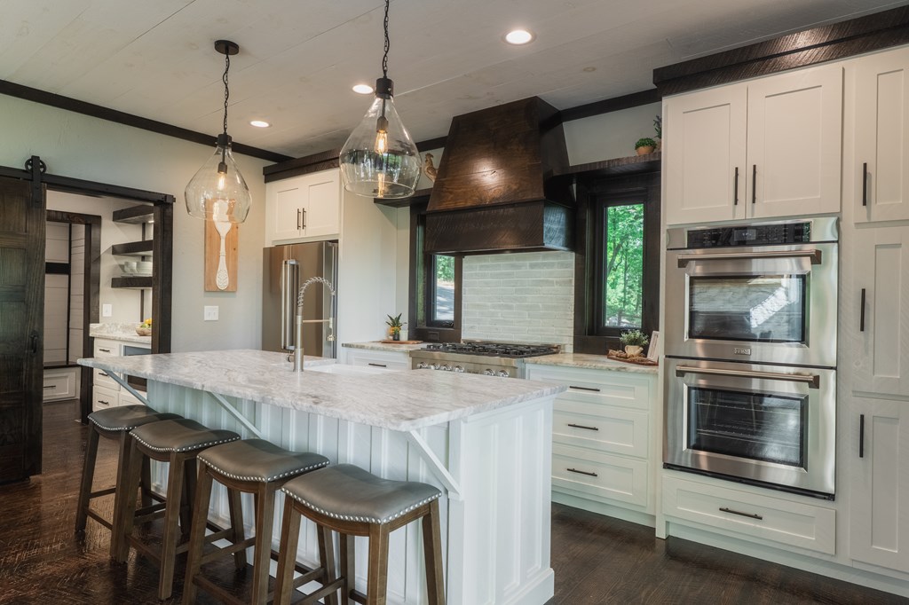 741 Price Road Blue Ridge, GA 30513 - Photo 6 of 58 a kitchen with kitchen island a stove and a chandelier