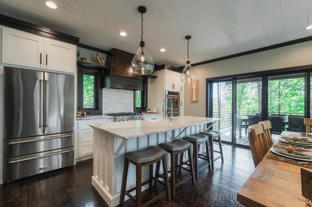 741 Price Road Blue Ridge, GA 30513 - Photo 10 of 58 a kitchen with stainless steel appliances granite countertop a stove a refrigerator a kitchen island a dining table and chairs