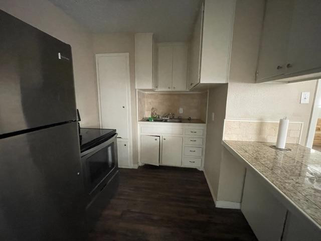 4119 32nd Street, Unit REAR Lubbock, TX 79410 - Photo 3 of 9 a kitchen with granite countertop a sink stove and refrigerator