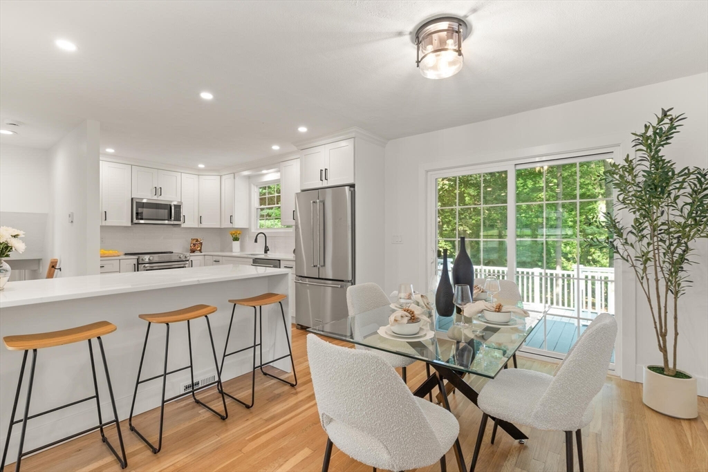 a view of a dining room with furniture a chandelier and wooden floor