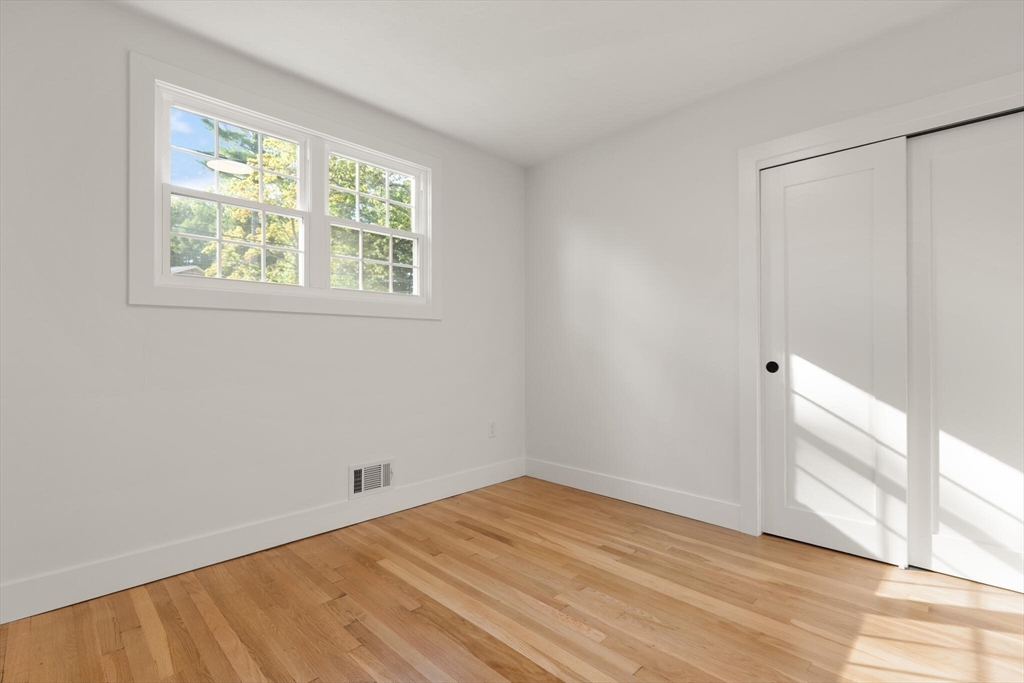 77 Morton Street Canton, MA 02021 - Photo 14 of 28 a view of an empty room with wooden floor and a window