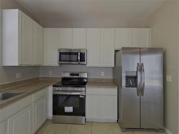a kitchen with a refrigerator stove and microwave