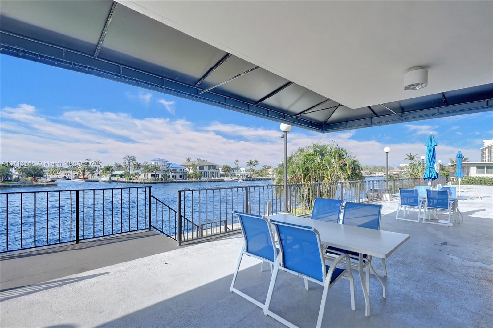521 North Riverside Drive, Unit 705 Pompano Beach, FL 33062 - Photo 47 of 55 a view of a patio with a table and chairs