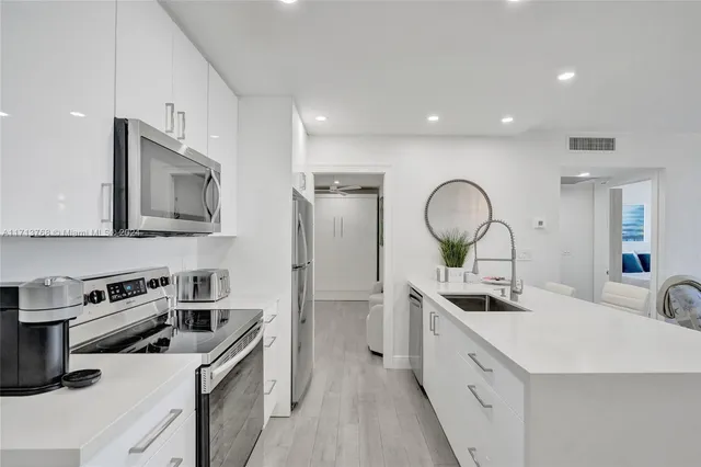 a kitchen with stainless steel appliances a sink stove and cabinets