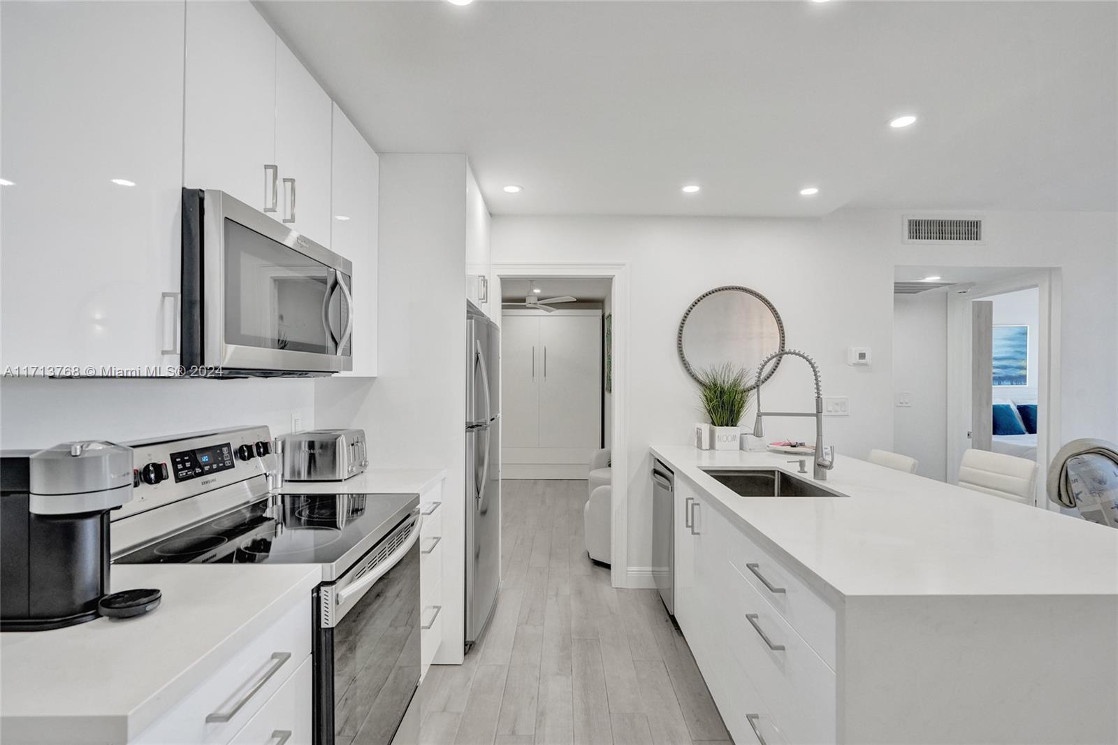 521 North Riverside Drive, Unit 705 Pompano Beach, FL 33062 - Photo 7 of 55 a kitchen with stainless steel appliances a sink stove and cabinets