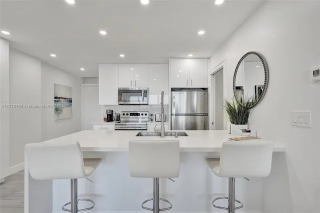 a kitchen with stainless steel appliances a sink cabinets and wooden floor