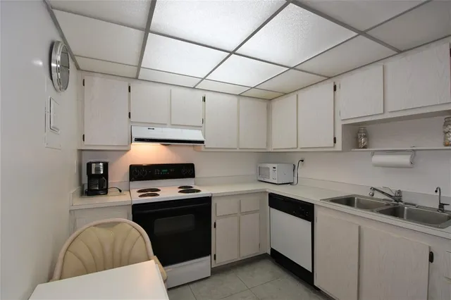 a kitchen with cabinets appliances a sink and a counter top