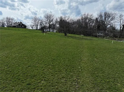 a view of a field with ocean in background