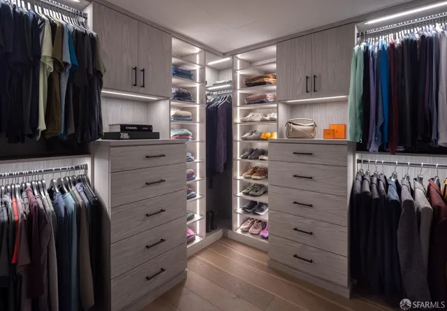 a view of walk in closet with clothes and shoes