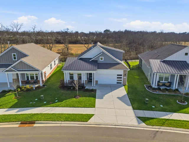 a kitchen with stainless steel appliances granite countertop a sink a stove a refrigerator cabinets and chairs
