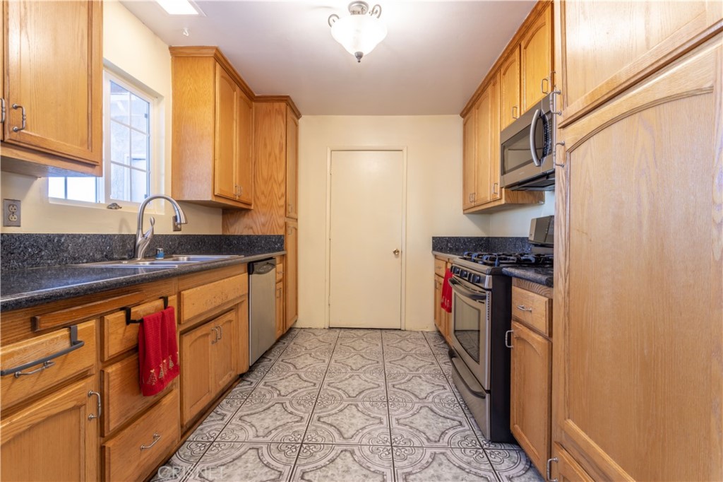 9021 Oneida Avenue Sun Valley, CA 91352 - Photo 12 of 36 a kitchen with stainless steel appliances granite countertop a stove a sink and a refrigerator