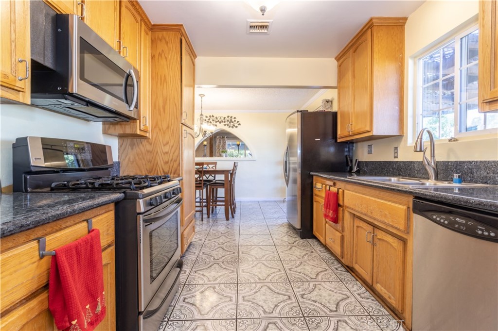 9021 Oneida Avenue Sun Valley, CA 91352 - Photo 13 of 36 a kitchen with stainless steel appliances granite countertop a stove a sink and a microwave