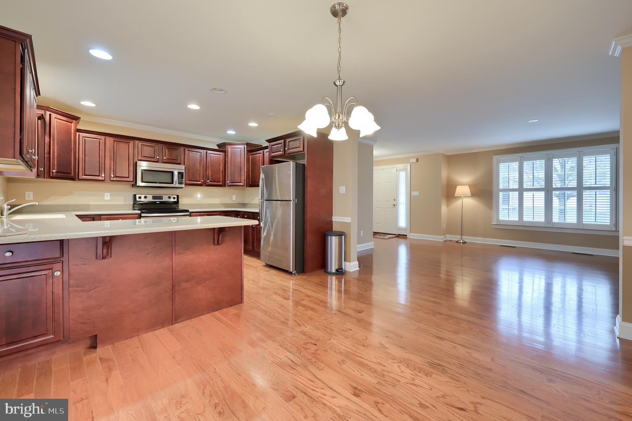 120 Baneberry Lane Lititz, PA 17543 - Photo 11 of 36 a kitchen with stainless steel appliances granite countertop a refrigerator a sink dishwasher a stove and a dining table with wooden floor