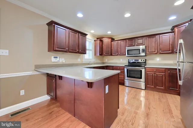 a kitchen with wooden cabinets and stainless steel appliances