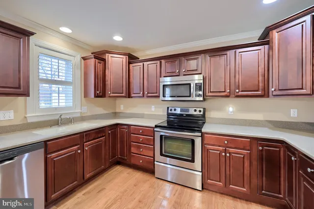 a kitchen with wooden cabinets sink and window