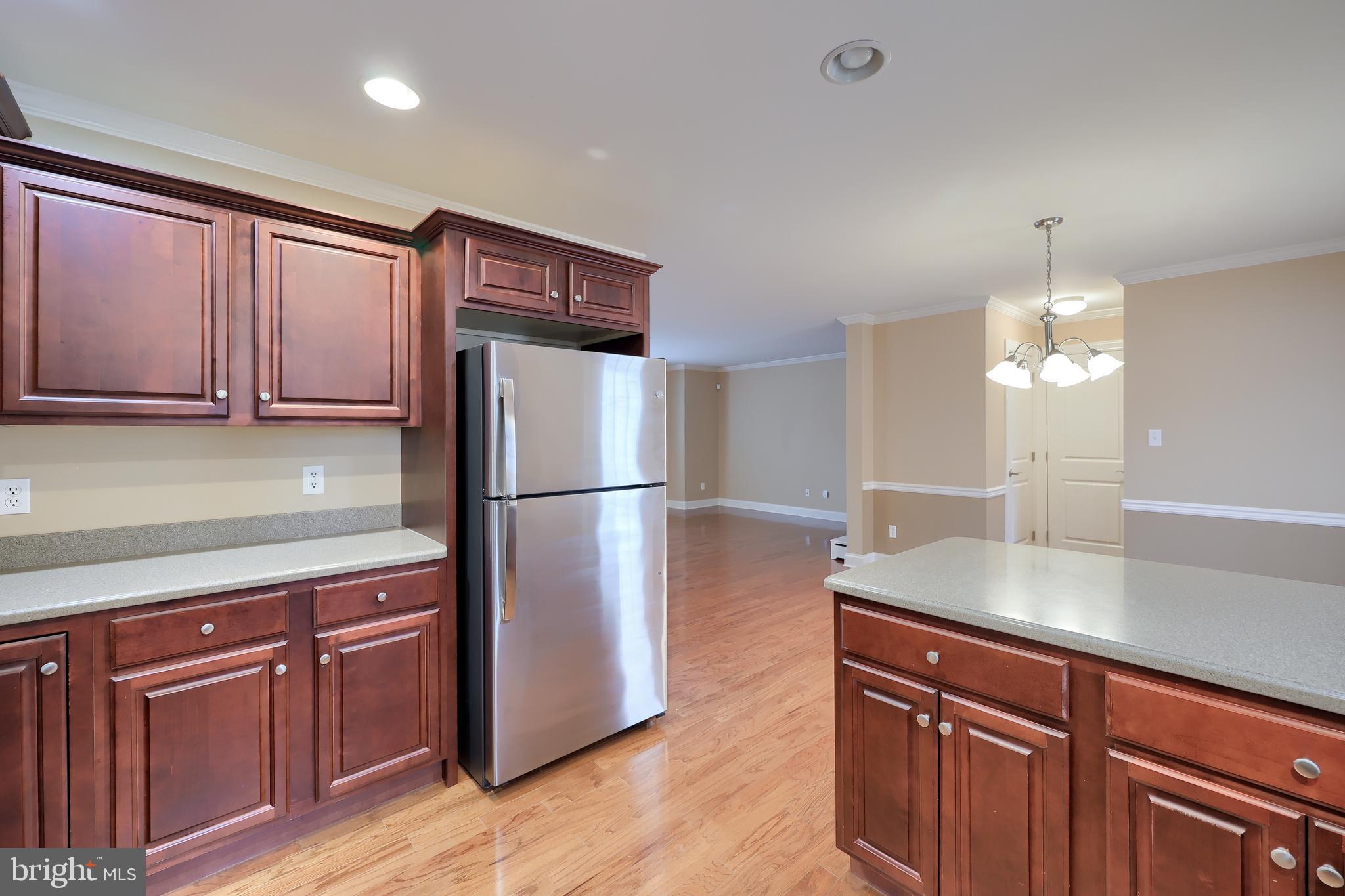 120 Baneberry Lane Lititz, PA 17543 - Photo 16 of 36 a kitchen with kitchen island granite countertop wooden cabinets a refrigerator with wooden floors