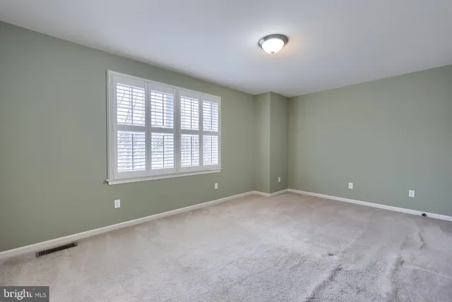 an empty room with windows and cabinet