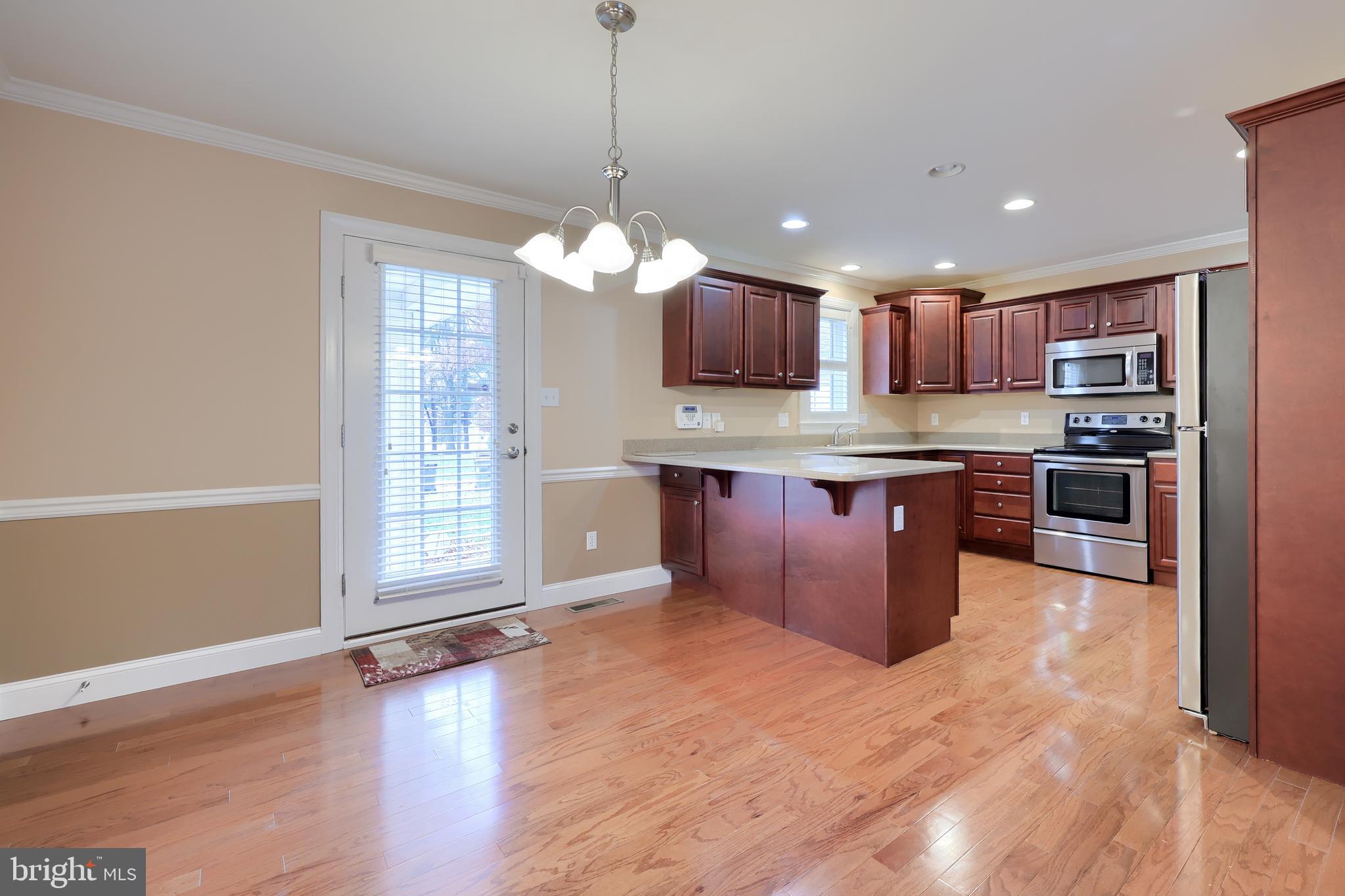120 Baneberry Lane Lititz, PA 17543 - Photo 8 of 36 a large kitchen with stainless steel appliances granite countertop a stove a sink dishwasher a refrigerator and a wooden cabinets