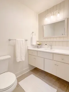 a bathroom with a sink a toilet and mirror