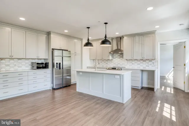 a large kitchen with a center island stainless steel appliances and cabinets