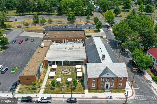 an aerial view of a multi story building with yard