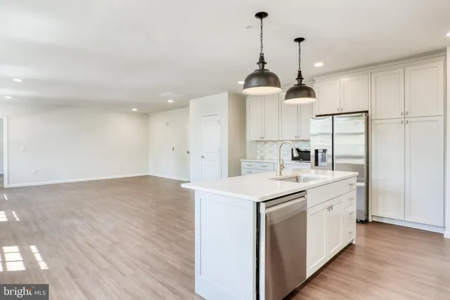 a kitchen that has a lot of cabinets and wooden floor