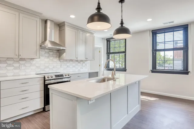 a kitchen that has a sink a stove and a window