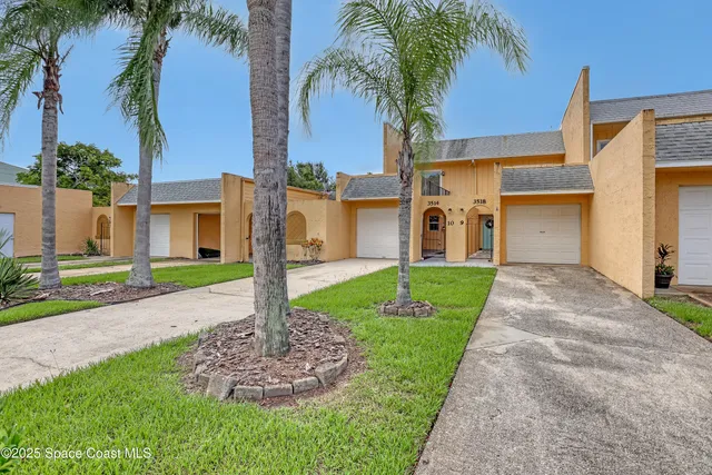 a front view of a house with a yard and palm tree
