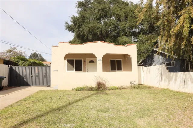 a view of a white house with wooden fence