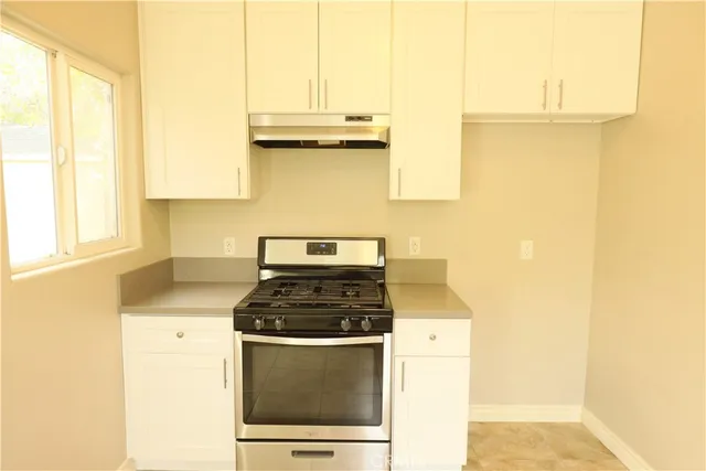 a kitchen with a stove a sink and a window