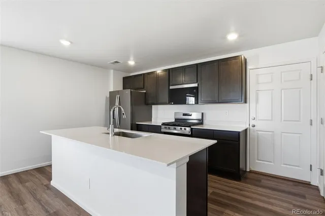 a kitchen with kitchen island a sink appliances and cabinets
