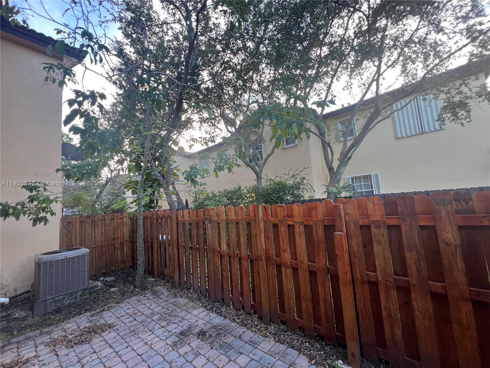 9217 Southwest 227th Street, Unit 11 Cutler Bay, FL 33190 - Photo 11 of 11 a wooden fence covered with tall trees