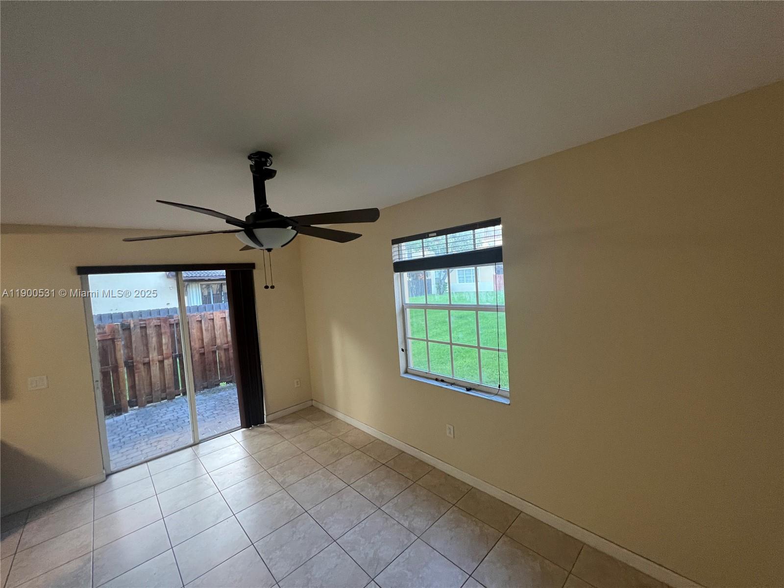 9217 Southwest 227th Street, Unit 11 Cutler Bay, FL 33190 - Photo 2 of 11 a view of an empty room with glass door