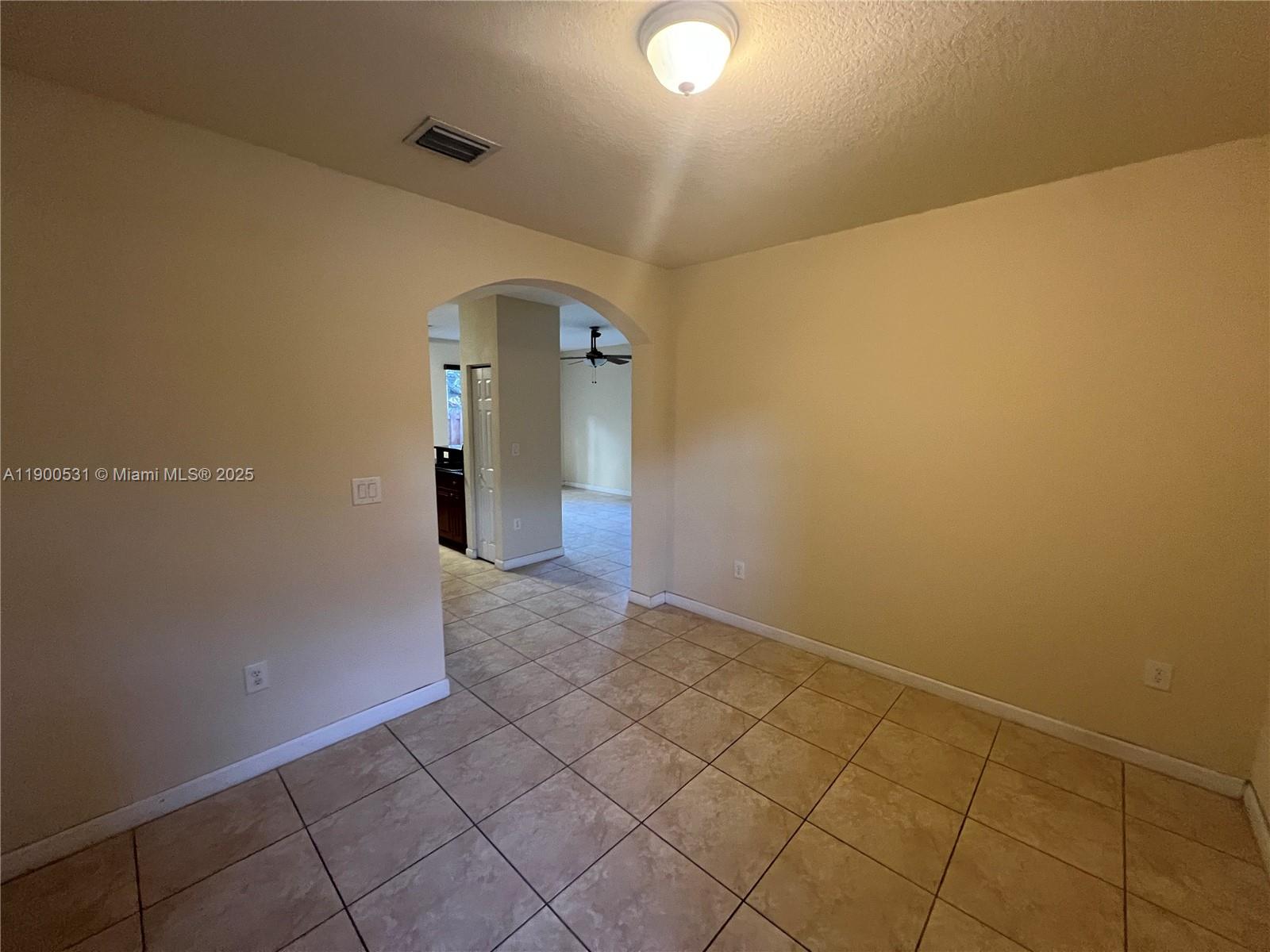 9217 Southwest 227th Street, Unit 11 Cutler Bay, FL 33190 - Photo 3 of 11 an empty room with wooden floor and mirror