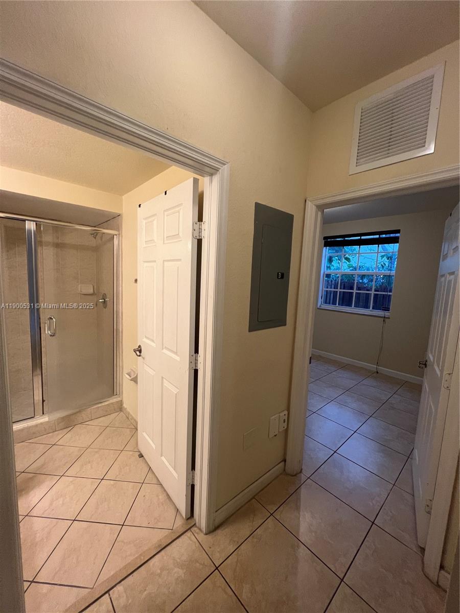 9217 Southwest 227th Street, Unit 11 Cutler Bay, FL 33190 - Photo 4 of 11 a bathroom with a glass door shower and a sink