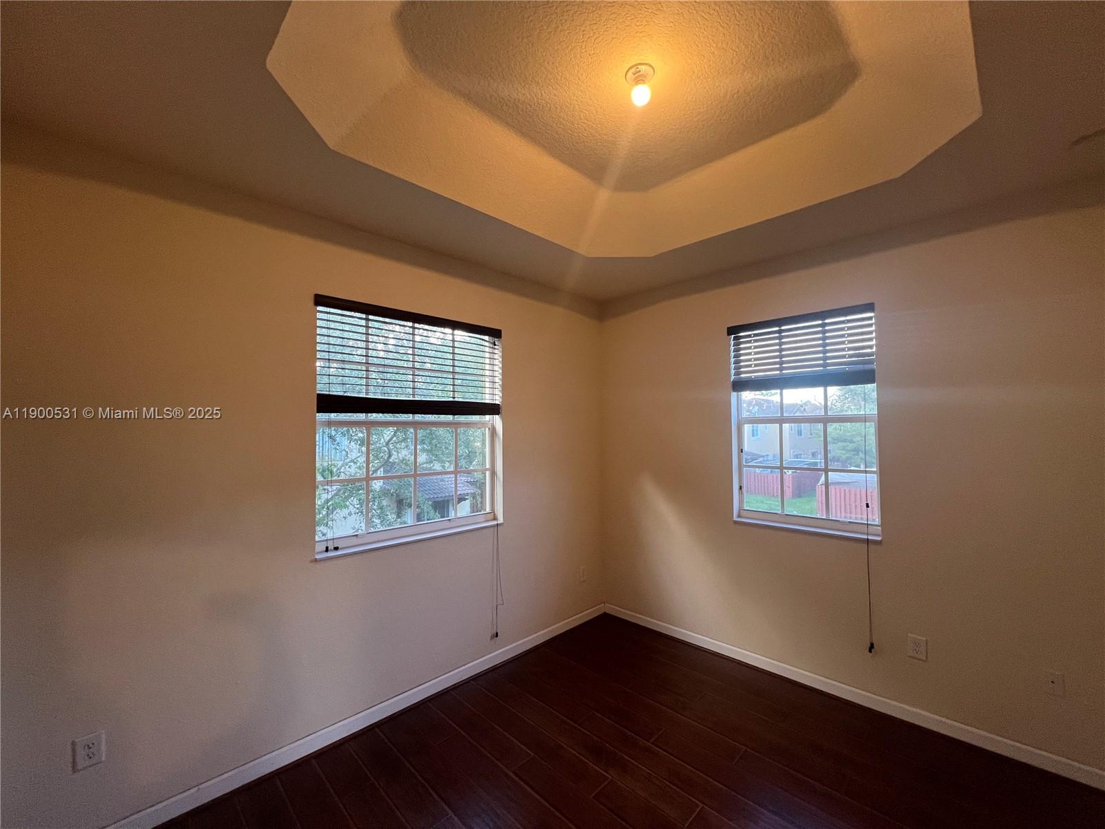 9217 Southwest 227th Street, Unit 11 Cutler Bay, FL 33190 - Photo 7 of 11 a view of an empty room with wooden floor and a window