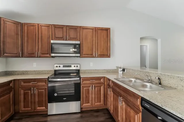 a kitchen with a sink stove and microwave