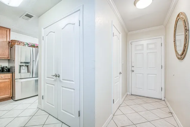 a view of a refrigerator in kitchen and white cabinets