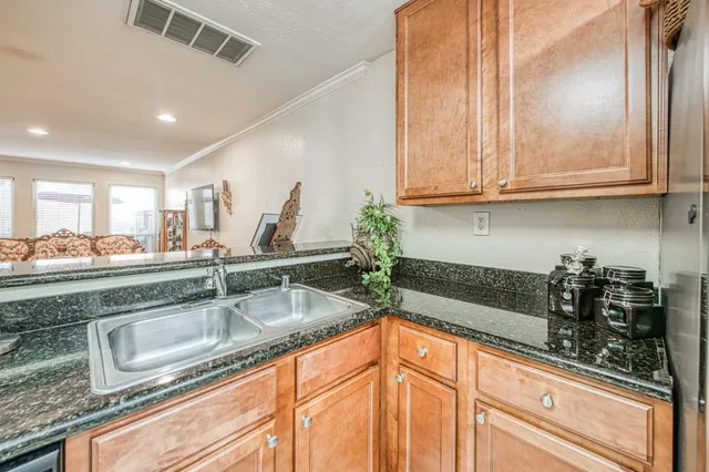 a kitchen with stainless steel appliances granite countertop a sink and a white cabinets