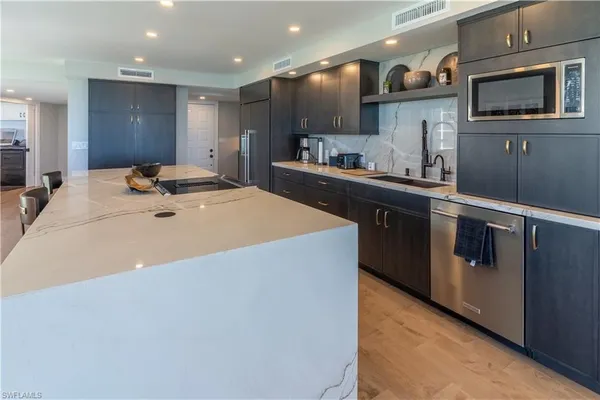 a kitchen with stainless steel appliances granite countertop a sink and a stove