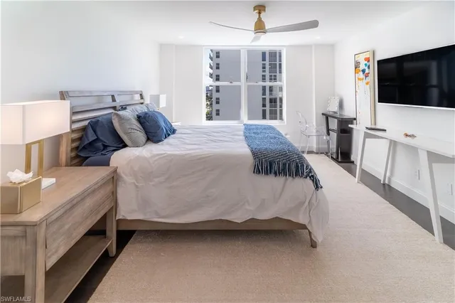 a spacious bedroom with a bed and a flat screen tv