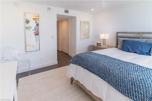 a bedroom with a bed and painting on the wall