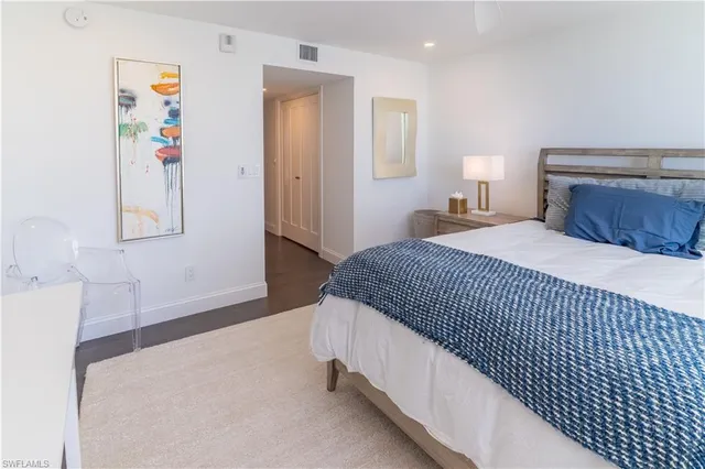 a bedroom with a bed and painting on the wall