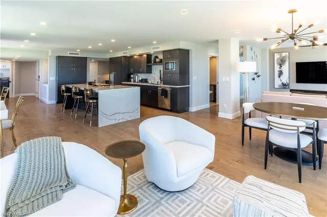a living room with furniture a flat screen tv and kitchen view