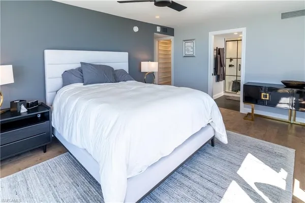 a large bed sitting in a bedroom next to a window with pc on the dresser