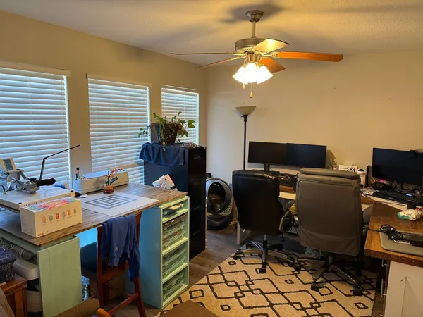 a view of a workspace with furniture and a window