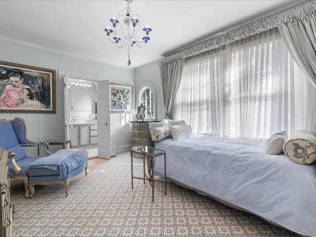 a bedroom with a bed and a chandelier